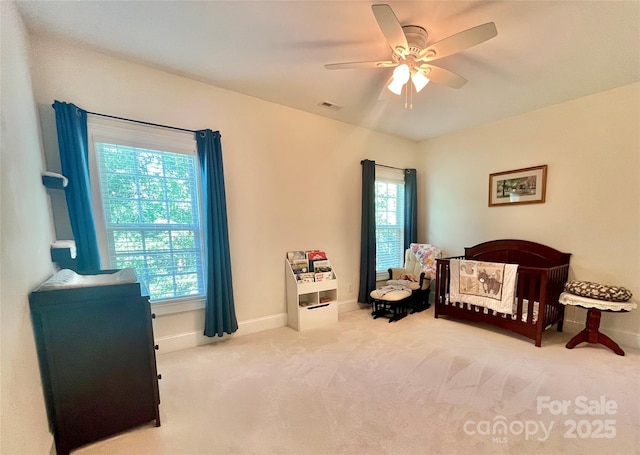 1025 N Sharon Amity Rd, Charlotte, NC 28211 - carpeted bedroom with multiple windows, baseboards, a ceiling fan, and a crib