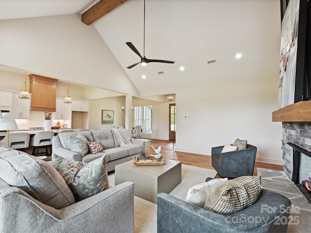1172 Springlake Rd, York, SC 29745 - living area featuring high vaulted ceiling, beamed ceiling, a stone fireplace, light wood finished floors, and a ceiling fan