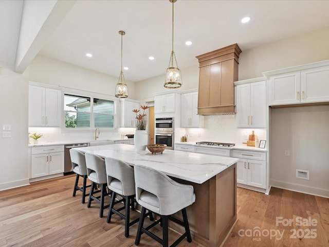 1172 Springlake Rd, York, SC 29745 - kitchen with stainless steel appliances, a kitchen island, tasteful backsplash, white cabinetry, and a sink