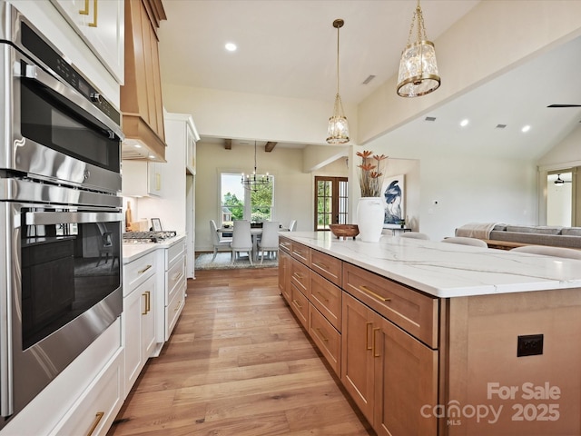 1172 Springlake Rd, York, SC 29745 - kitchen featuring appliances with stainless steel finishes, open floor plan, a chandelier, a kitchen island, and light wood-type flooring