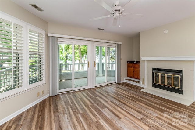 302 NW Dr, Davidson, NC 28036 - unfurnished living room featuring wood finished floors, a fireplace, and a ceiling fan