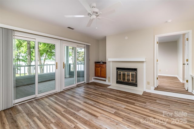 302 NW Dr, Davidson, NC 28036 - unfurnished living room with wood finished floors, a fireplace, and ceiling fan