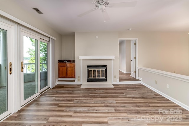 302 NW Dr, Davidson, NC 28036 - unfurnished living room featuring wood finished floors, a tile fireplace, and a ceiling fan