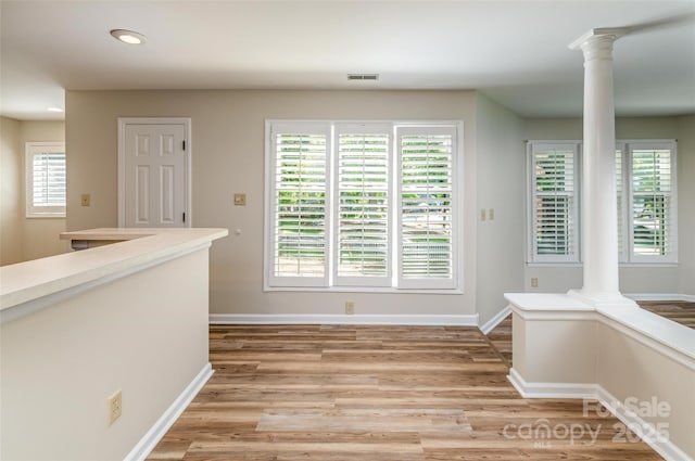 302 NW Dr, Davidson, NC 28036 - unfurnished dining area with decorative columns, light wood finished floors, and recessed lighting