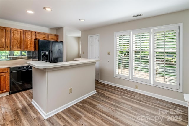 302 NW Dr, Davidson, NC 28036 - kitchen with black appliances, light wood finished floors, light countertops, brown cabinetry, and recessed lighting