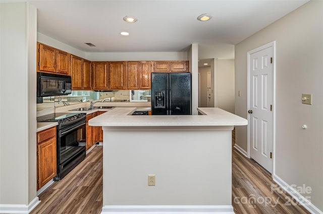 302 NW Dr, Davidson, NC 28036 - kitchen featuring black appliances, light countertops, light wood finished floors, a kitchen island, and brown cabinetry