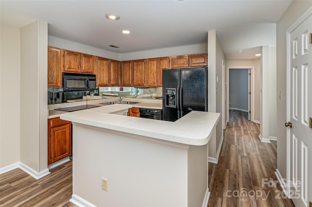 302 NW Dr, Davidson, NC 28036 - kitchen with black appliances, wood finished floors, brown cabinetry, and recessed lighting