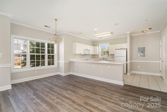 8969 Meadow Vista Rd, Charlotte, NC 28213 - kitchen featuring white appliances, electric panel, a chandelier, wood finished floors, and light countertops