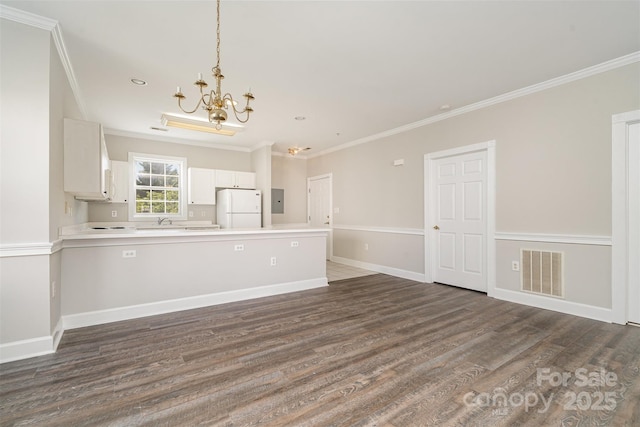8969 Meadow Vista Rd, Charlotte, NC 28213 - kitchen featuring freestanding refrigerator, crown molding, a chandelier, a peninsula, and dark wood-style flooring
