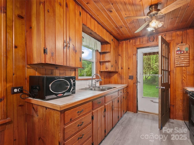 49 Caring Place Loop, Clyde, NC 28721 - kitchen featuring a sink, tile counters, wood ceiling, brown cabinets, and light wood finished floors