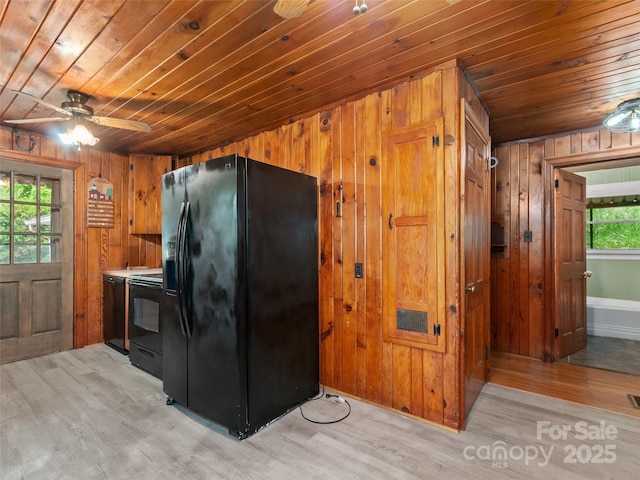 49 Caring Place Loop, Clyde, NC 28721 - kitchen featuring black appliances, wooden ceiling, wood walls, light wood-style floors, and a ceiling fan