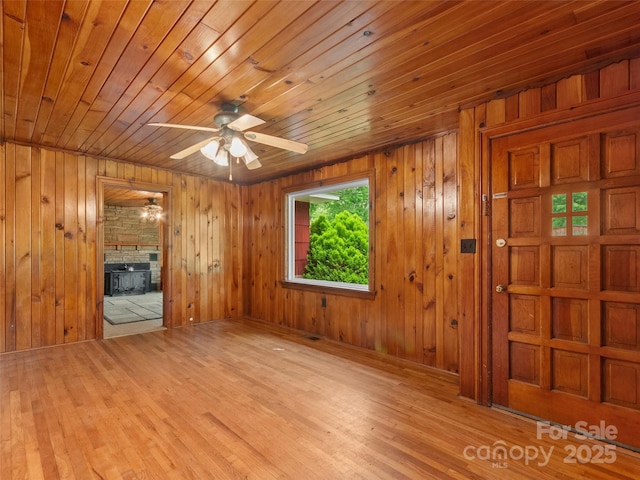 49 Caring Place Loop, Clyde, NC 28721 - unfurnished living room with a ceiling fan, a fireplace, wood ceiling, wood finished floors, and wooden walls