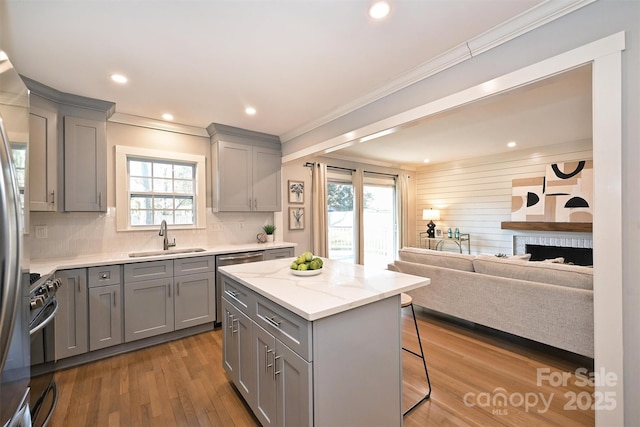 532 Scaleybark Rd, Charlotte, NC 28209 - kitchen with gray cabinets, a sink, ornamental molding, a breakfast bar area, and recessed lighting