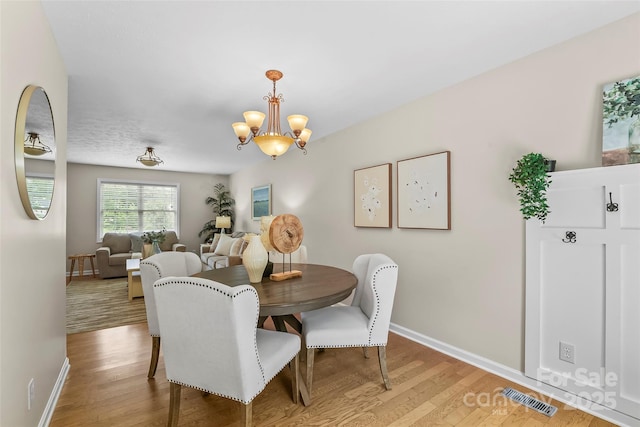 205 Davis Dr, Morganton, NC 28655 - dining space with wood finished floors, a chandelier, and baseboards