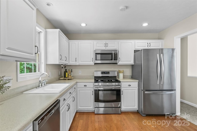205 Davis Dr, Morganton, NC 28655 - kitchen with appliances with stainless steel finishes, a sink, white cabinets, light countertops, and recessed lighting