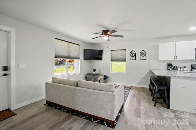 13821 David St, Huntersville, NC 28078 - living area featuring a ceiling fan, light wood-style floors, and baseboards