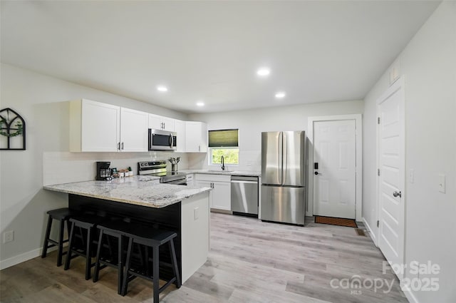 13821 David St, Huntersville, NC 28078 - kitchen featuring appliances with stainless steel finishes, a sink, a peninsula, backsplash, and a breakfast bar area
