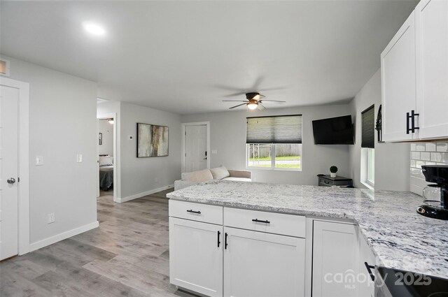 13821 David St, Huntersville, NC 28078 - kitchen with a peninsula, a ceiling fan, white cabinetry, light wood finished floors, and light stone counters