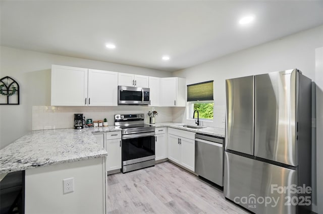 13821 David St, Huntersville, NC 28078 - kitchen featuring stainless steel appliances, a sink, a peninsula, white cabinets, and tasteful backsplash