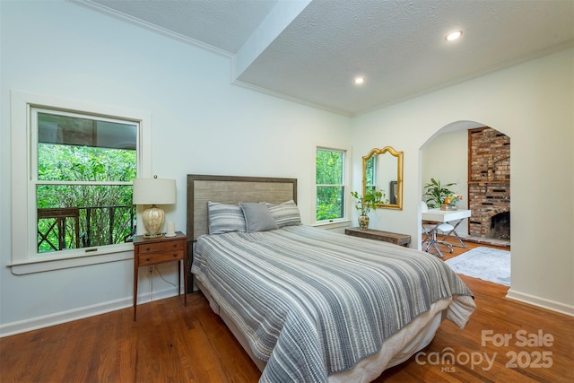 528 Padgettown Rd, Black Mountain, NC 28711 - bedroom with ornamental molding, baseboards, a textured ceiling, arched walkways, and wood finished floors