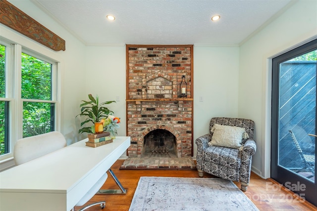 528 Padgettown Rd, Black Mountain, NC 28711 - living area with wood finished floors, a textured ceiling, recessed lighting, a brick fireplace, and crown molding