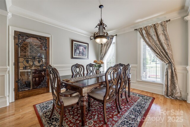 546 Little Cove Ln, Lake Wylie, SC 29710 - dining area featuring crown molding, light wood finished floors, a wainscoted wall, and a decorative wall