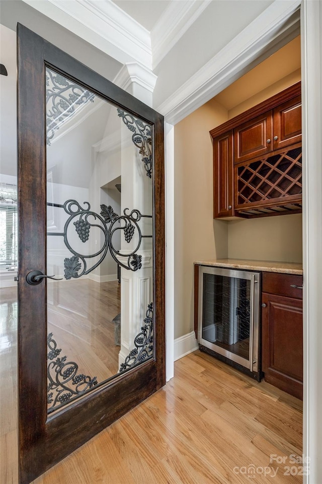 546 Little Cove Ln, Lake Wylie, SC 29710 - wine cellar featuring wine cooler, a dry bar, crown molding, light wood-style floors, and baseboards