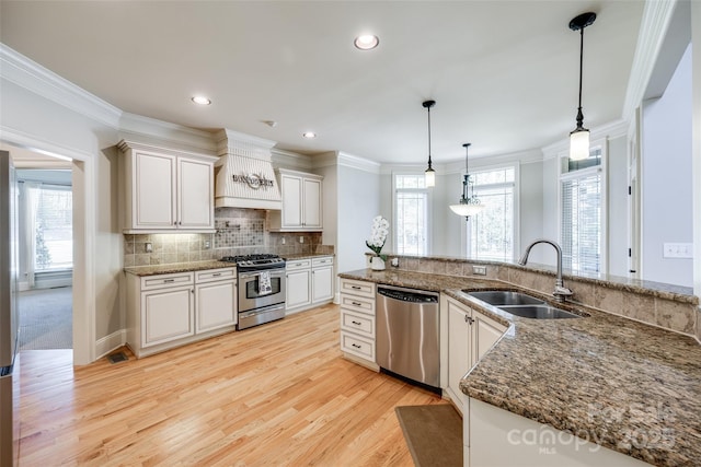 546 Little Cove Ln, Lake Wylie, SC 29710 - kitchen with stainless steel appliances, a sink, light wood-style flooring, crown molding, and white cabinets