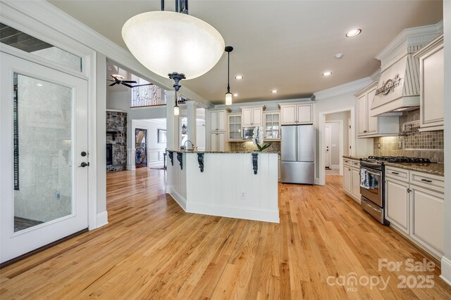 546 Little Cove Ln, Lake Wylie, SC 29710 - kitchen featuring stainless steel appliances, decorative backsplash, glass insert cabinets, a breakfast bar, and crown molding