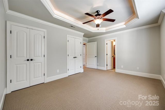 546 Little Cove Ln, Lake Wylie, SC 29710 - unfurnished bedroom featuring a raised ceiling, two closets, light colored carpet, crown molding, and baseboards