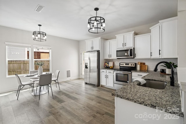 3092 Riker St, Clover, SC 29710 - kitchen with stainless steel appliances, a chandelier, a sink, and backsplash