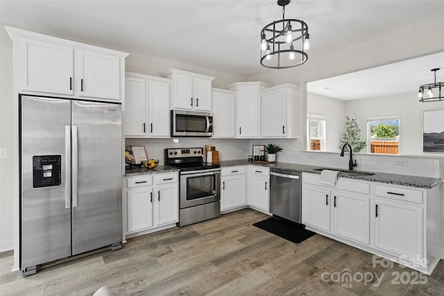 3092 Riker St, Clover, SC 29710 - kitchen featuring stainless steel appliances, a sink, a chandelier, light wood-style floors, and backsplash