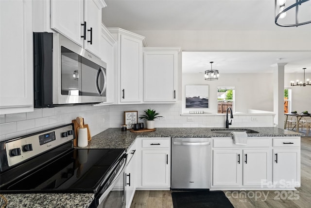 3092 Riker St, Clover, SC 29710 - kitchen featuring appliances with stainless steel finishes, a chandelier, a sink, a peninsula, and light wood finished floors