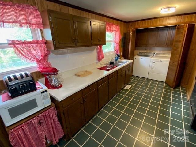 13427 Homewood Dr, Charlotte, NC 28262 - kitchen featuring independent washer and dryer, crown molding, white microwave, dark tile patterned floors, and wooden walls