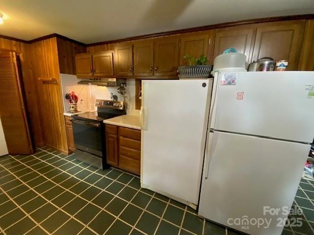 13427 Homewood Dr, Charlotte, NC 28262 - kitchen with range with electric cooktop, freestanding refrigerator, under cabinet range hood, and brown cabinetry