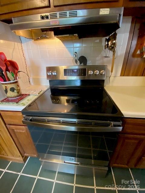 13427 Homewood Dr, Charlotte, NC 28262 - kitchen featuring stainless steel electric range, under cabinet range hood, light countertops, and decorative backsplash