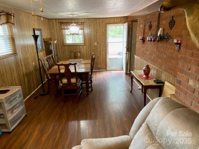 13427 Homewood Dr, Charlotte, NC 28262 - dining room with wood finished floors, wooden walls, brick wall, and baseboards