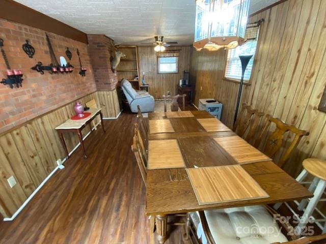 13427 Homewood Dr, Charlotte, NC 28262 - dining area featuring wood walls, wood finished floors, a ceiling fan, and brick wall