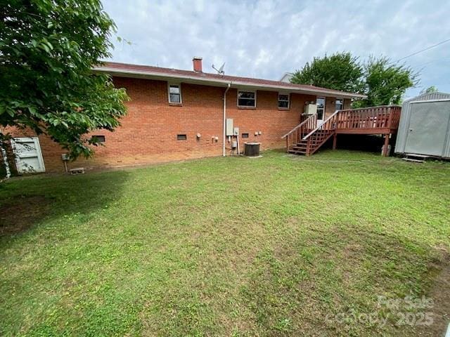 13427 Homewood Dr, Charlotte, NC 28262 - rear view of house featuring crawl space, a deck, brick siding, a lawn, and a chimney