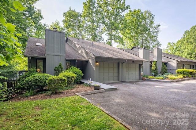 206 Independence Trl, Morganton, NC 28655 - mid-century modern home with a chimney, a garage, roof with shingles, and asphalt driveway