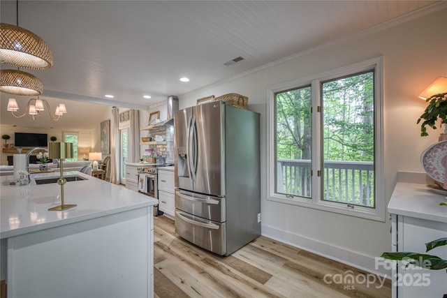 206 Independence Trl, Morganton, NC 28655 - kitchen featuring appliances with stainless steel finishes, a sink, white cabinets, ornamental molding, and light wood finished floors