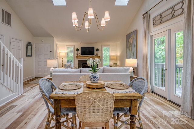 206 Independence Trl, Morganton, NC 28655 - dining room featuring lofted ceiling, stairs, a chandelier, light wood-style floors, and a skylight
