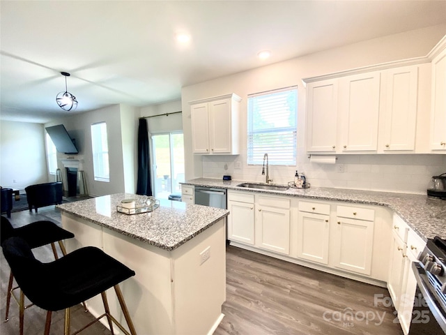 7024 Wheyfield Dr, Charlotte, NC 28215 - kitchen featuring a sink, tasteful backsplash, white cabinetry, stainless steel appliances, and a center island