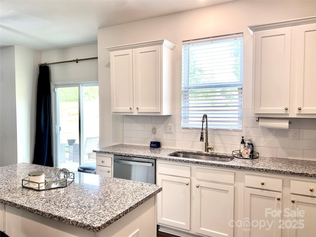 7024 Wheyfield Dr, Charlotte, NC 28215 - kitchen with a sink, stainless steel dishwasher, decorative backsplash, and white cabinets