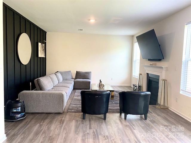 7024 Wheyfield Dr, Charlotte, NC 28215 - living room with light wood-style flooring, healthy amount of natural light, a glass covered fireplace, and baseboards