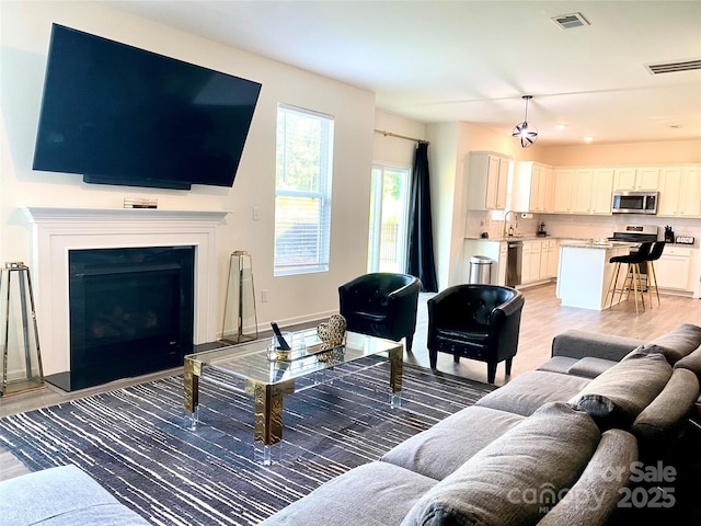 7024 Wheyfield Dr, Charlotte, NC 28215 - living area with light wood-type flooring and a fireplace
