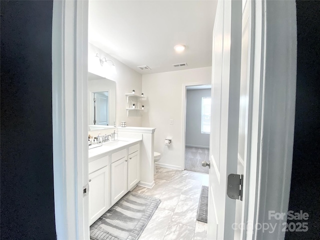 7024 Wheyfield Dr, Charlotte, NC 28215 - bathroom featuring toilet, marble look tiles, vanity, and baseboards