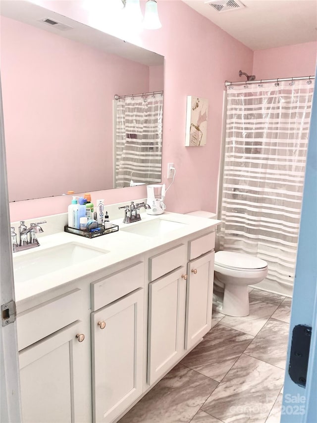 7024 Wheyfield Dr, Charlotte, NC 28215 - full bathroom with toilet, double vanity, and marble finish flooring
