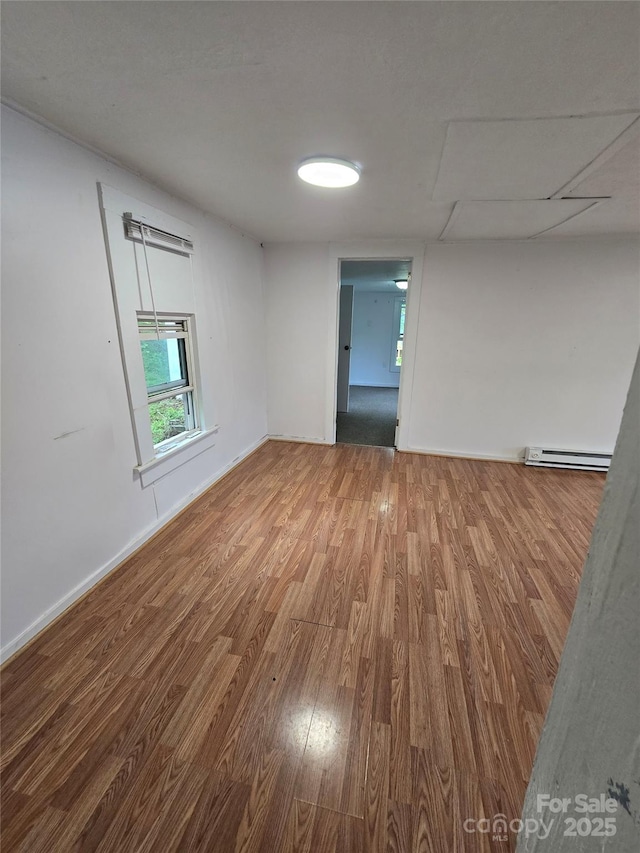 151 S Hill St, Waynesville, NC 28786 - empty room featuring a baseboard radiator, wood finished floors, and baseboards