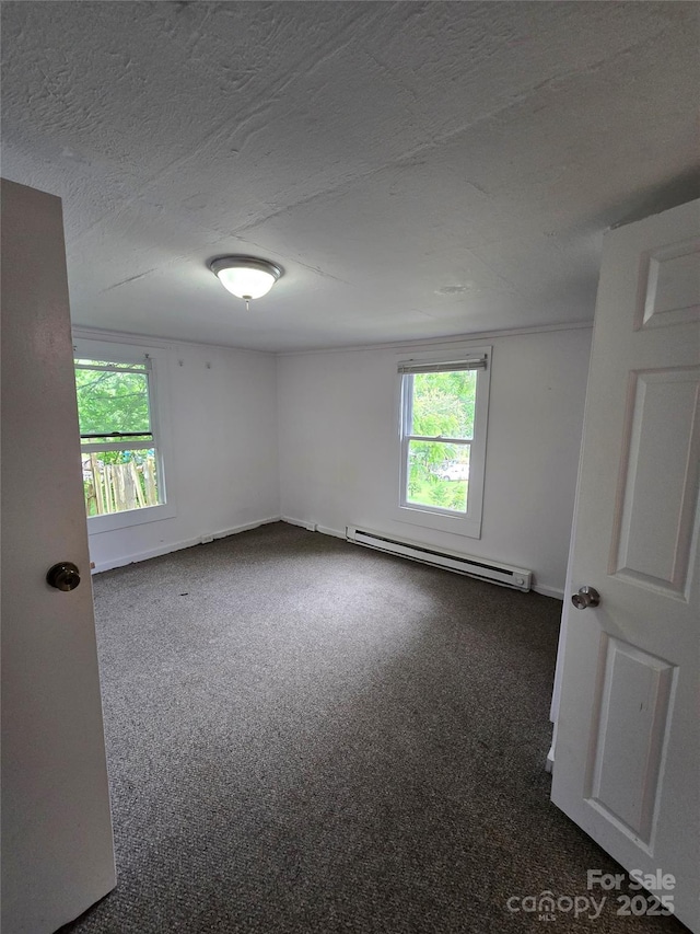 151 S Hill St, Waynesville, NC 28786 - carpeted empty room with a baseboard heating unit, plenty of natural light, and a textured ceiling